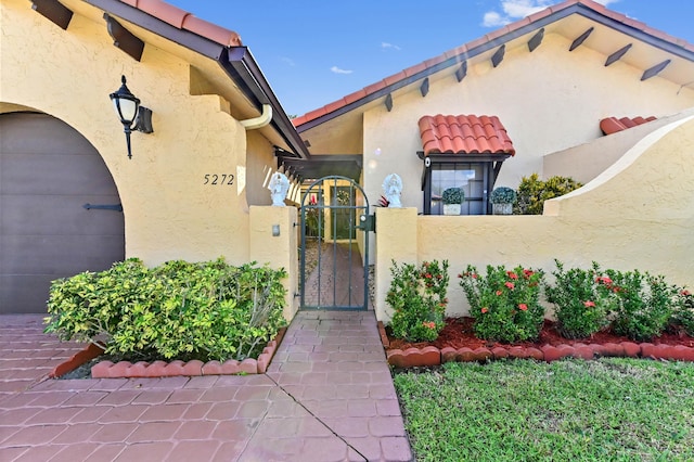 5272 Bolero Cir, Delray Beach, FL 33484 - entrance to property featuring stucco siding, a gate, and a tiled roof