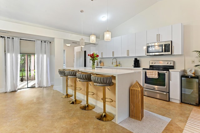 5272 Bolero Cir, Delray Beach, FL 33484 - kitchen with stainless steel appliances, light countertops, a sink, lofted ceiling, and a breakfast bar