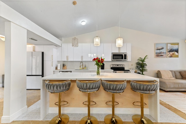 5272 Bolero Cir, Delray Beach, FL 33484 - kitchen with appliances with stainless steel finishes, a sink, light countertops, vaulted ceiling, and white cabinetry