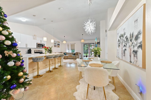 dining area with high vaulted ceiling and a notable chandelier