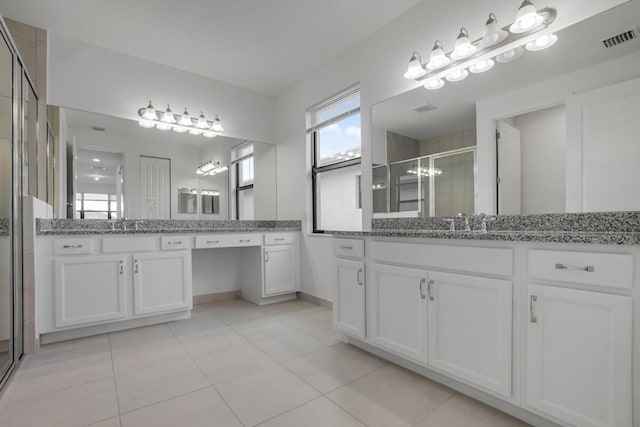 bathroom featuring a shower with door, vanity, and tile patterned flooring