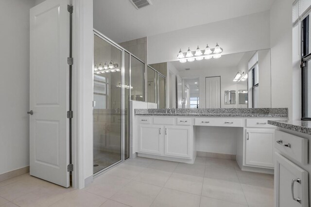 bathroom with tile patterned floors, vanity, toilet, and walk in shower