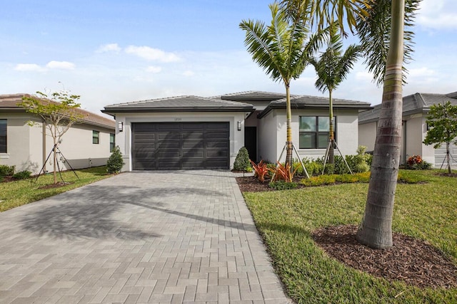 12535 SW Blue Mangrove Pkwy, Port Saint Lucie, FL 34987 - prairie-style house featuring a garage, stucco siding, decorative driveway, and a front yard