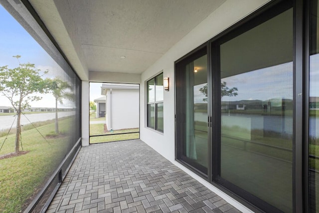 unfurnished sunroom featuring a water view