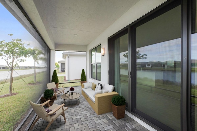 sunroom / solarium featuring a water view