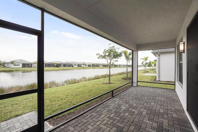 unfurnished sunroom with a water view