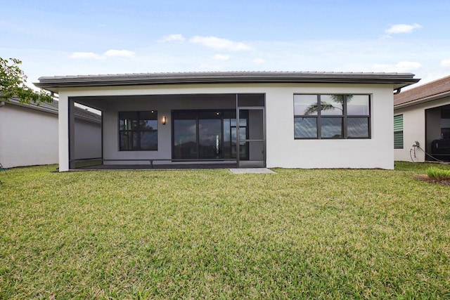 rear view of house with a lawn and a sunroom