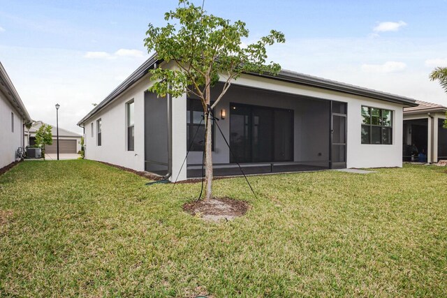 back of house featuring a yard, central AC, and a sunroom