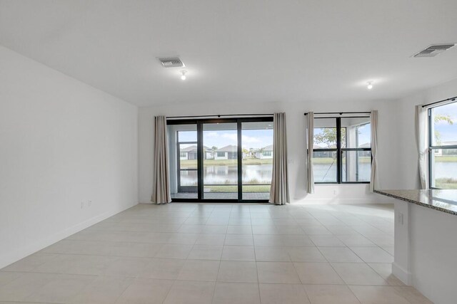 12535 SW Blue Mangrove Pkwy, Port Saint Lucie, FL 34987 - unfurnished room with light tile patterned floors, a water view, and baseboards