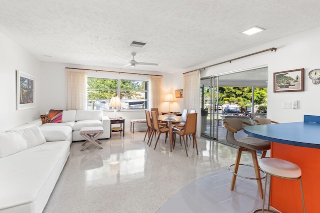 living room featuring a textured ceiling and ceiling fan