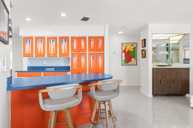 kitchen featuring a textured ceiling and tasteful backsplash