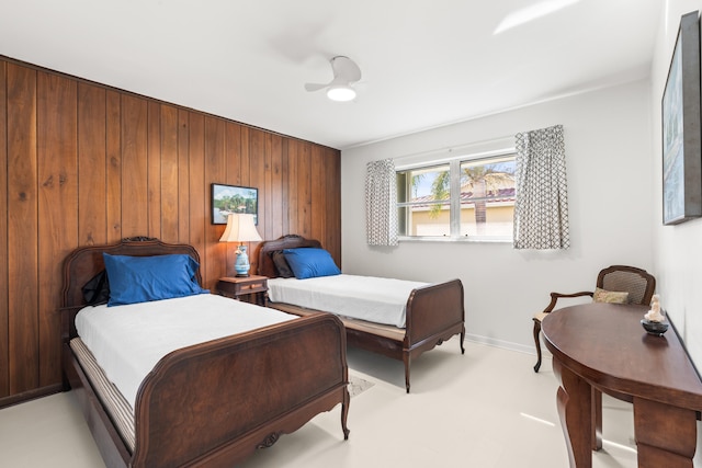 bedroom with ceiling fan and wood walls