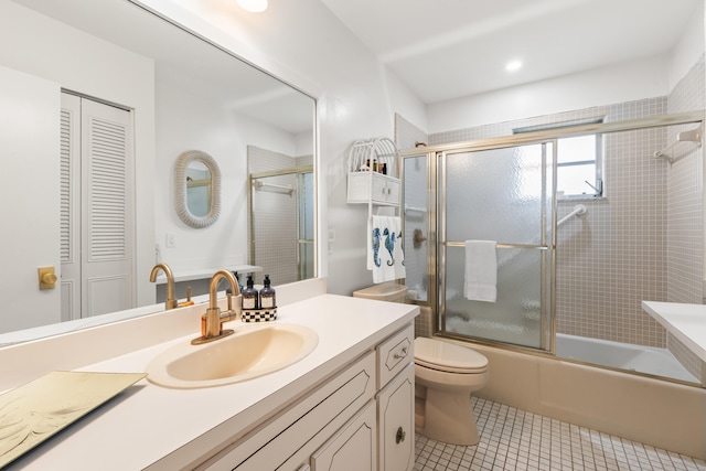 full bathroom with tile patterned flooring, vanity, toilet, and combined bath / shower with glass door