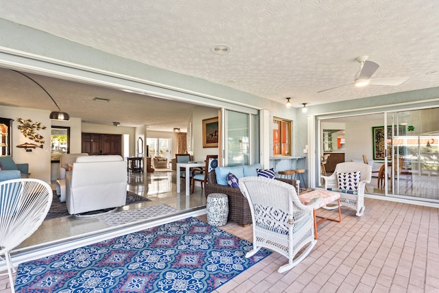 interior space with a textured ceiling and ceiling fan