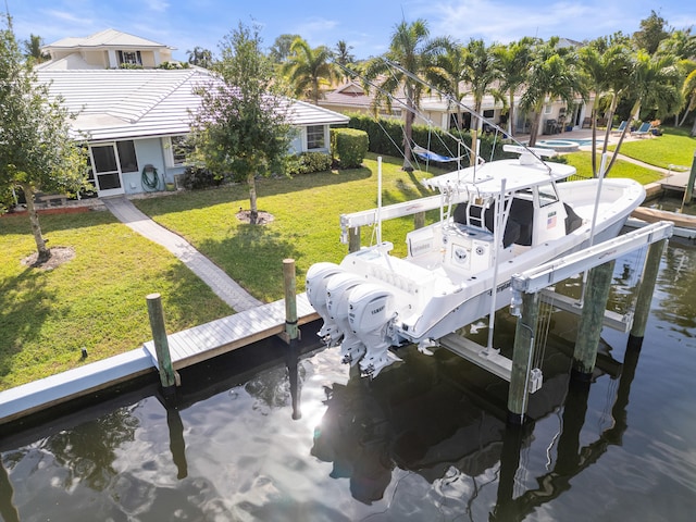 view of dock with a water view and a lawn