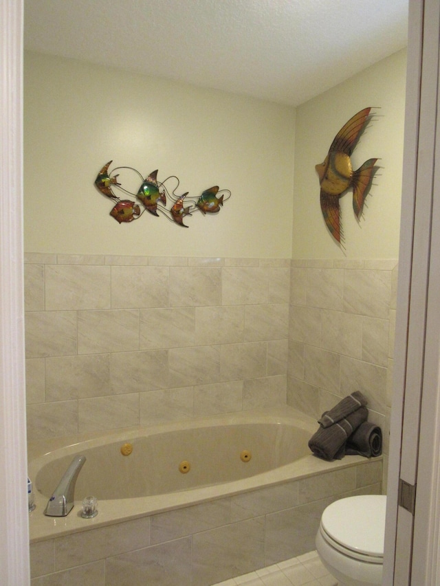 bathroom with tile patterned floors, toilet, and tiled tub