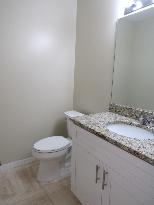 bathroom with tile patterned flooring, vanity, and toilet