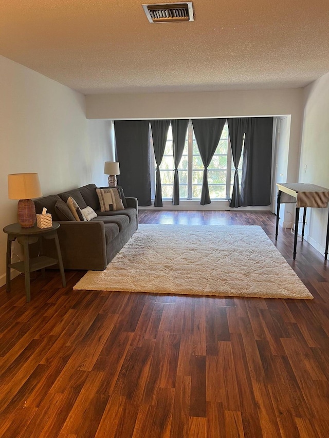 living room featuring dark hardwood / wood-style flooring and a textured ceiling