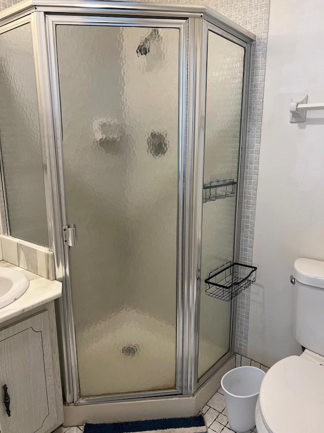 bathroom featuring toilet, tile patterned flooring, and walk in shower