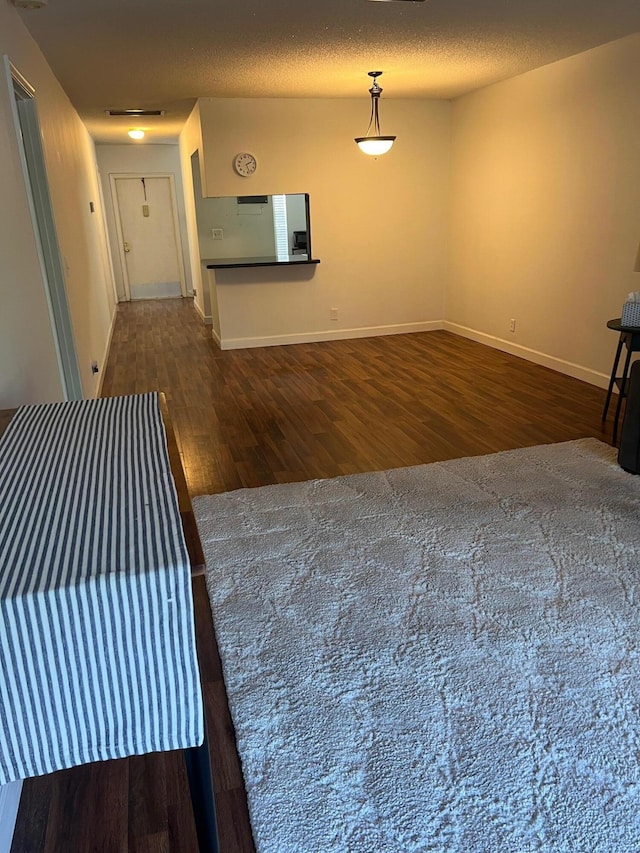 interior space featuring dark wood-type flooring and a textured ceiling