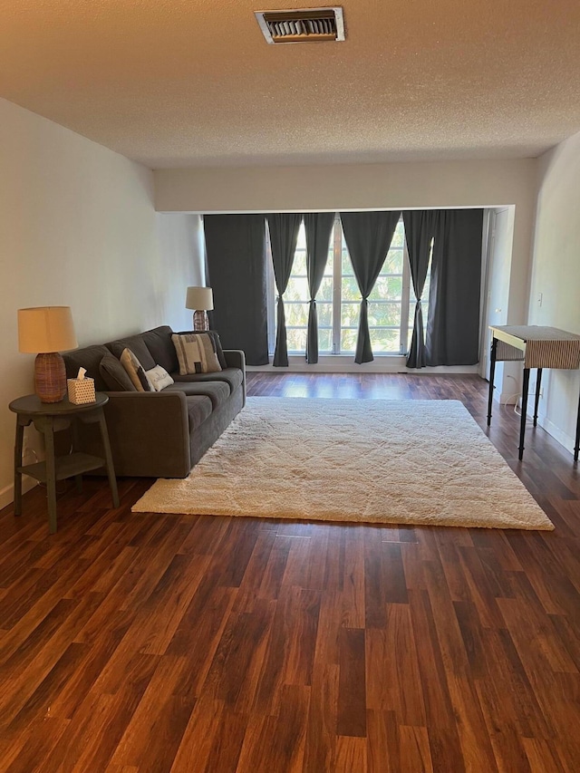 living room with dark hardwood / wood-style flooring and a textured ceiling