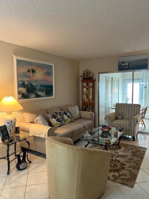 tiled living room featuring a textured ceiling