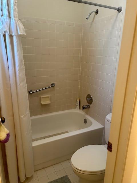 bathroom featuring tile patterned flooring, shower / bath combo, and toilet