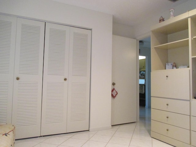 unfurnished bedroom with light tile patterned floors and a closet