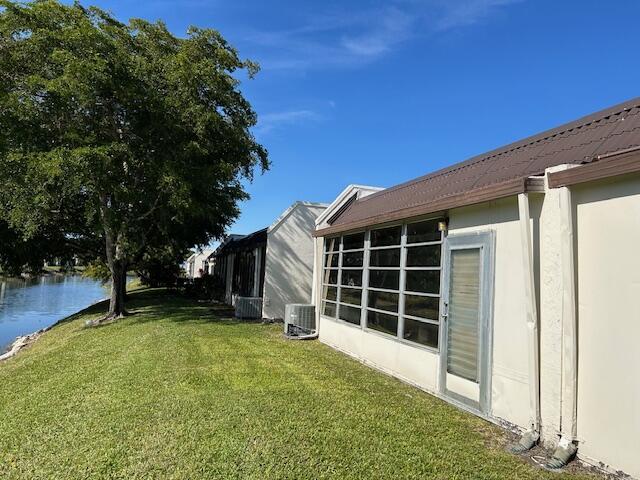 view of yard with central AC unit and a water view