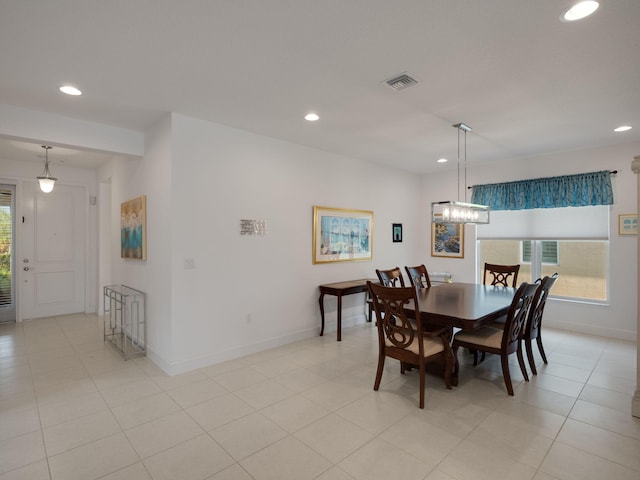 tiled dining room with an inviting chandelier