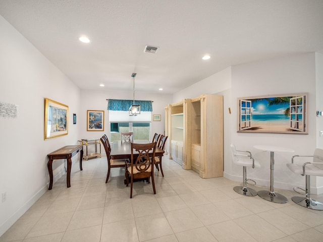 dining space with an inviting chandelier and light tile patterned flooring