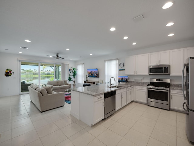 kitchen featuring white cabinetry, sink, light stone counters, kitchen peninsula, and appliances with stainless steel finishes