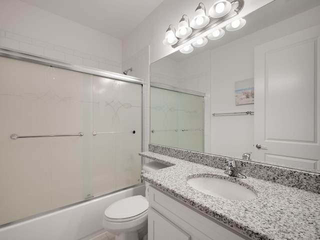 full bathroom with vanity, toilet, and bath / shower combo with glass door