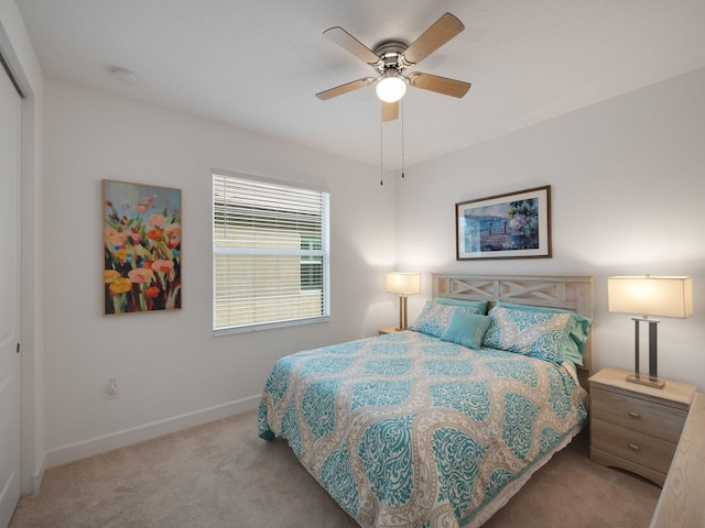 bedroom featuring a closet, ceiling fan, and light colored carpet