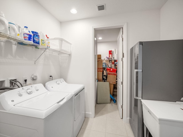 washroom featuring washer and dryer and light tile patterned flooring