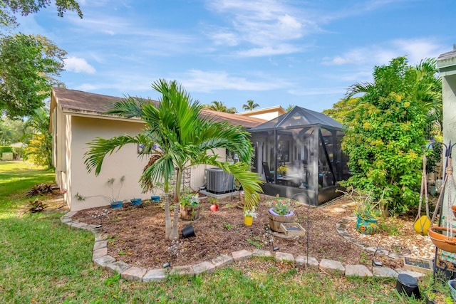 view of yard with a lanai and central AC unit