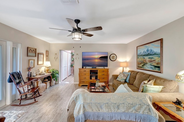 living room with ceiling fan and light hardwood / wood-style flooring