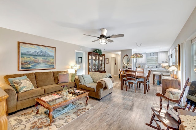 living room featuring ceiling fan and light hardwood / wood-style flooring