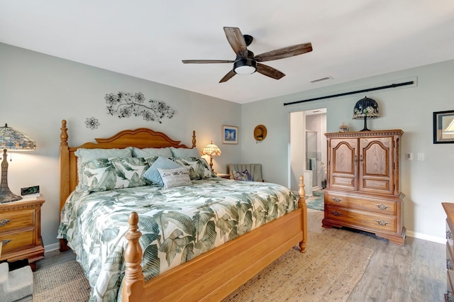 bedroom with ceiling fan, light hardwood / wood-style floors, and ensuite bathroom