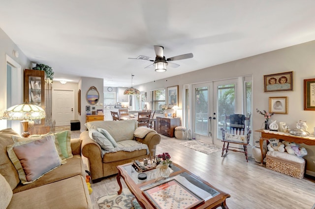 living room with french doors, light wood-type flooring, and ceiling fan