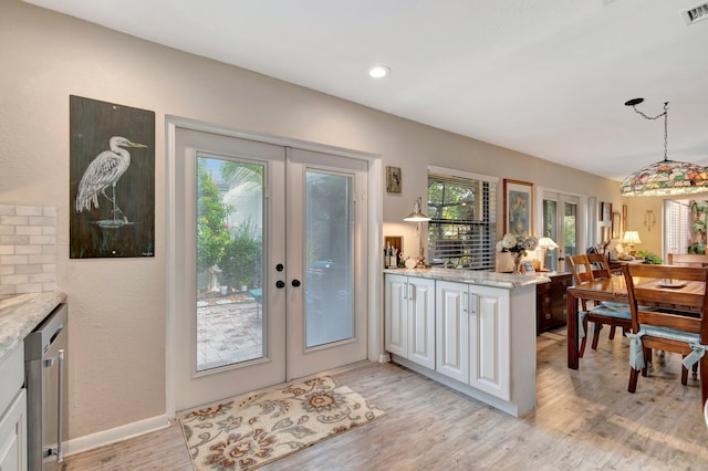 doorway with plenty of natural light, light hardwood / wood-style flooring, and french doors