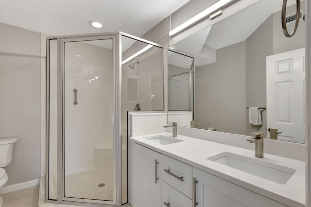 bathroom featuring tile patterned flooring, vanity, toilet, and walk in shower