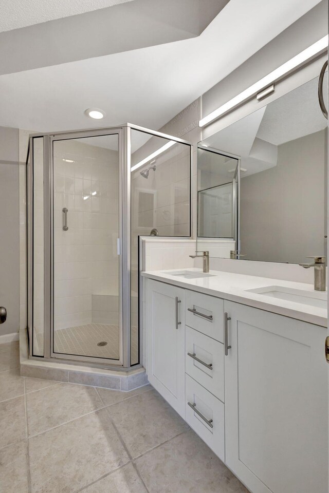 bathroom with tile patterned floors, vanity, and a shower with shower door