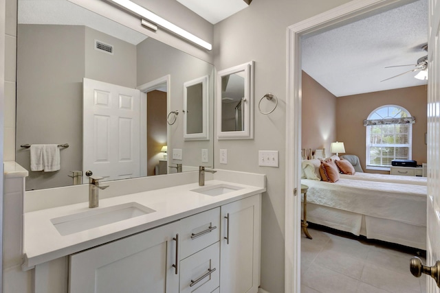 bathroom featuring ceiling fan, tile patterned flooring, vanity, and a textured ceiling