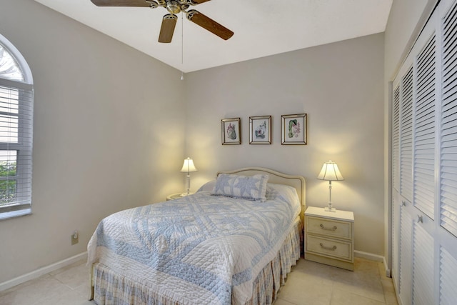 tiled bedroom with ceiling fan and a closet