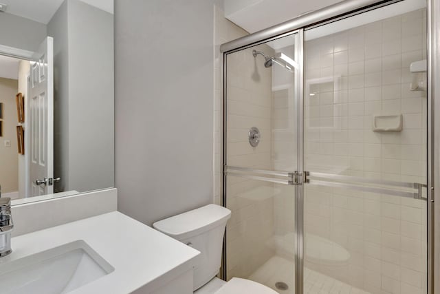 bathroom with vanity, toilet, and a shower with shower door