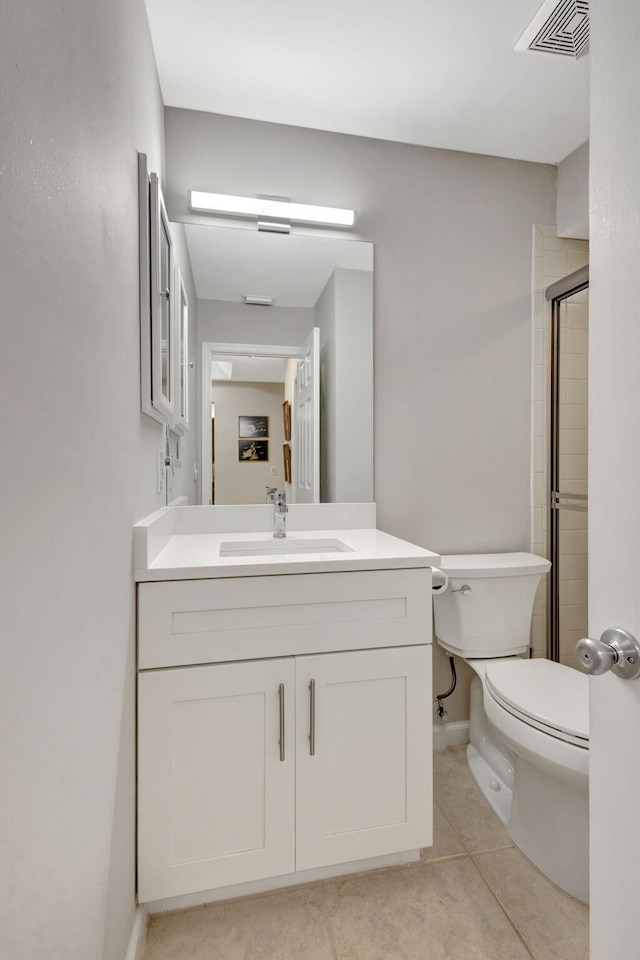 bathroom with tile patterned floors, toilet, vanity, and walk in shower