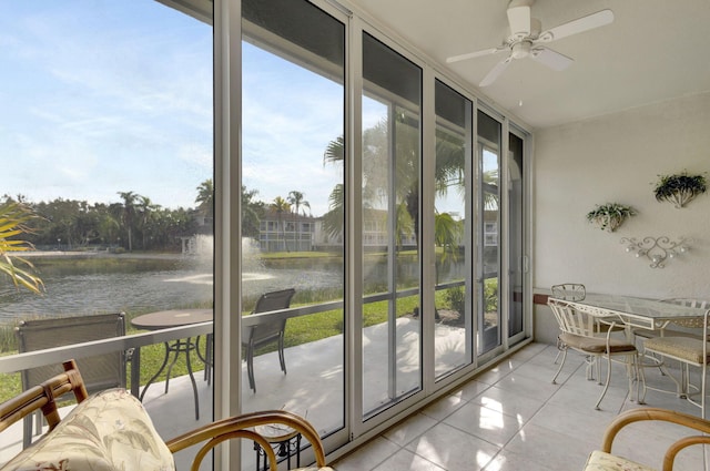 sunroom featuring ceiling fan and a water view