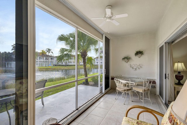 sunroom / solarium with a water view and ceiling fan