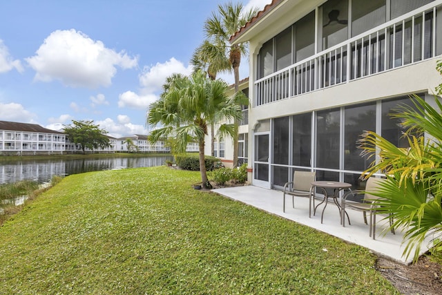 view of yard with a patio area, ceiling fan, and a water view